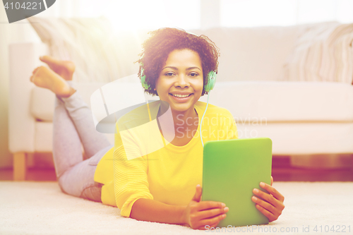 Image of happy african woman with tablet pc and headphones