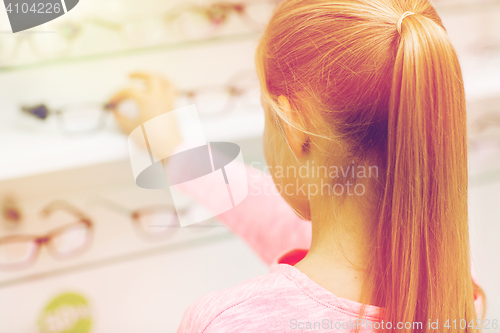 Image of close up of girl choosing glasses at optics store