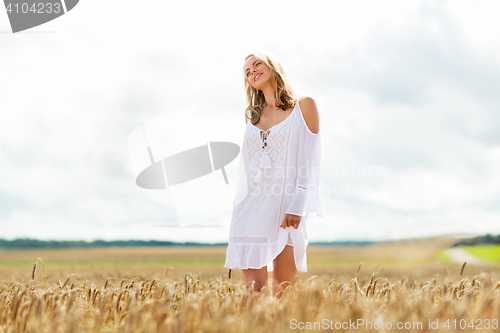 Image of smiling young woman in white dress on cereal field