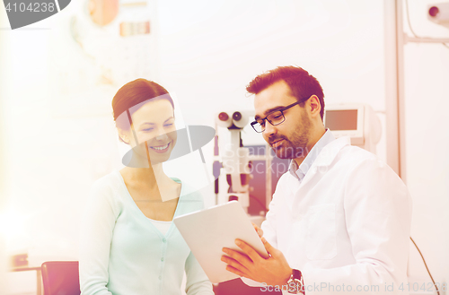 Image of optician with tablet pc and patient at eye clinic