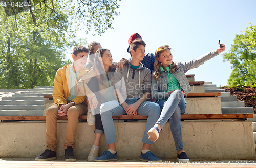 Image of happy teenage students taking selfie by smartphone