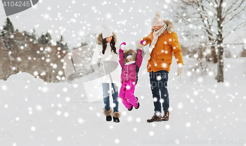 Image of happy family in winter clothes walking outdoors