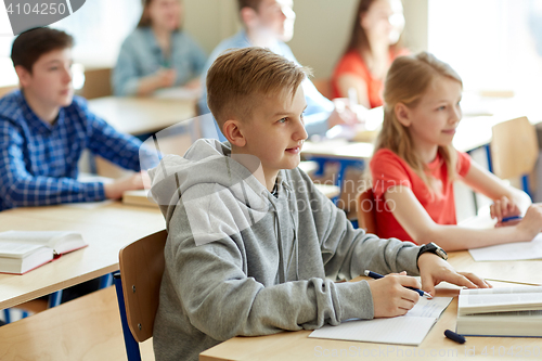 Image of group of students with notebooks at school lesson