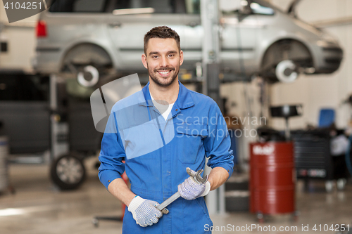 Image of auto mechanic or smith with wrench at car workshop