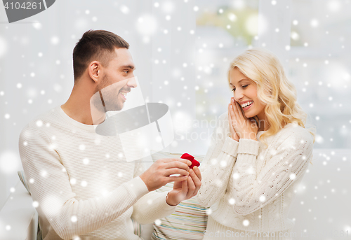 Image of man giving woman engagement ring for christmas