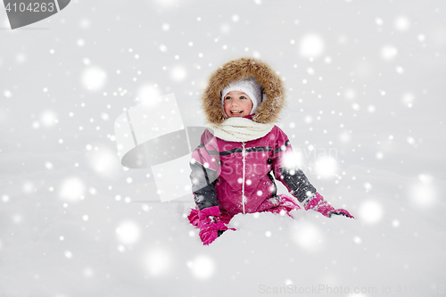 Image of happy little kid or girl in winter clothes on snow