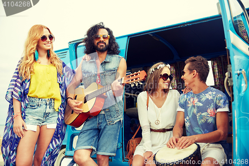 Image of happy hippie friends playing music over minivan