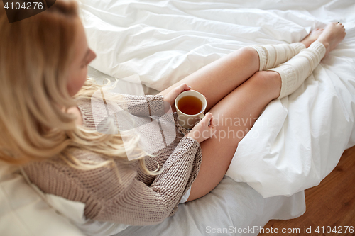 Image of close up of woman with tea cup in bed