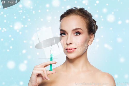 Image of beautiful woman holding syringe with injection