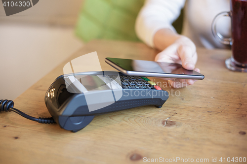 Image of Woman uses smart phone to pay