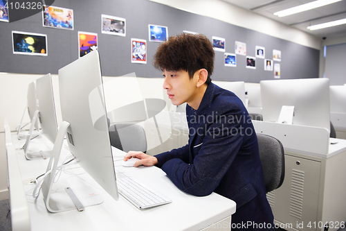 Image of young man using computer in classroom