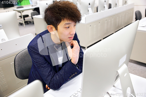 Image of young man using computer in classroom