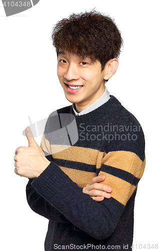 Image of Young laughing asian man showing thumb up hand gesture