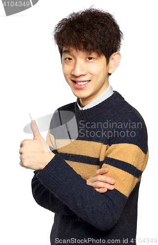 Image of Young laughing asian man showing thumb up hand gesture