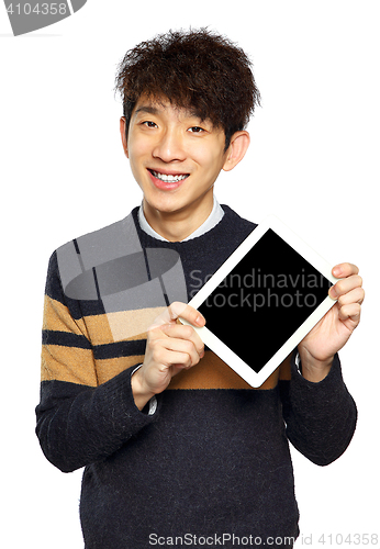 Image of Handsome young Asian man using tablet / pad