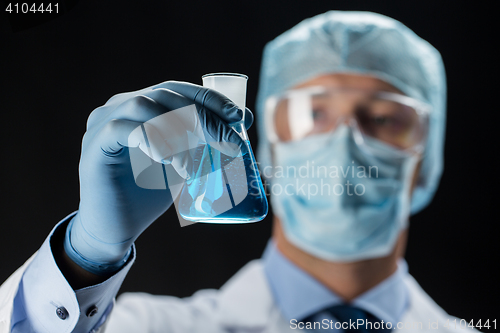 Image of close up of scientist holding flask with chemical