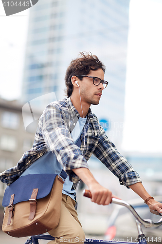 Image of young hipster man with bag riding fixed gear bike