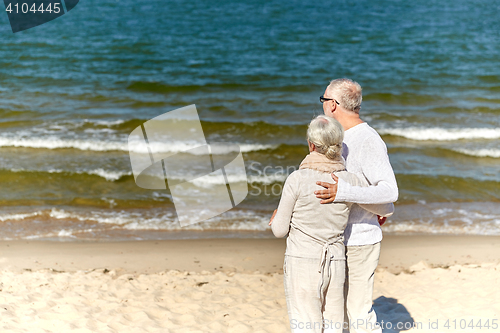 Image of happy senior couple hugging on summer beach