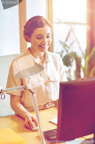 Image of happy business woman with computer at office