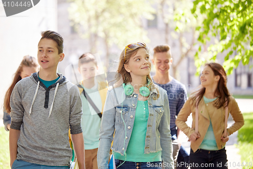 Image of group of happy teenage students walking outdoors