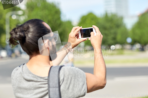 Image of hipster man taking picture on smartphone