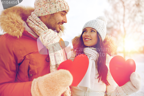 Image of happy couple with red hearts over winter landscape