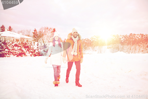 Image of happy couple walking along snowy winter field