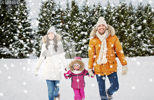 Image of happy family in winter clothes walking outdoors