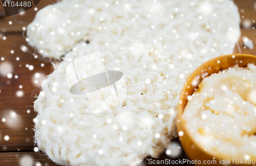 Image of close up of wisp and body scrub in cup on wood