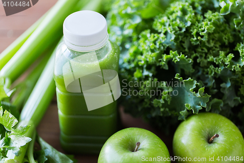 Image of close up of bottle with green juice and vegetables