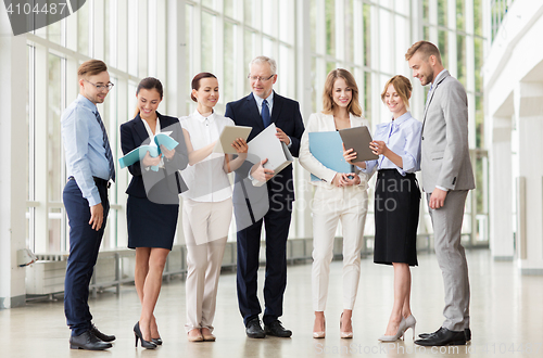 Image of business team with tablet pc and folders at office