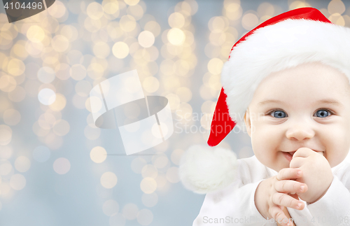 Image of happy baby in santa hat over holidays lights