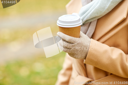 Image of close up of woman with coffee in autumn park