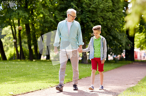 Image of grandfather and grandson walking at summer park