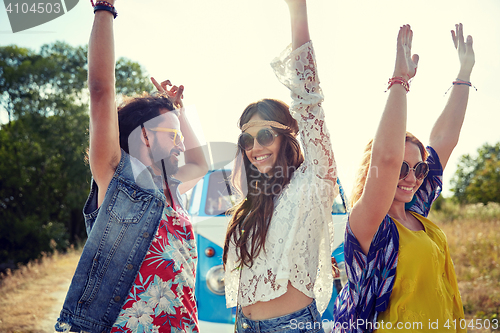 Image of happy young hippie friends dancing outdoors