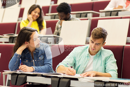 Image of group of students with notebooks in lecture hall