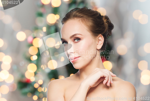 Image of beautiful young woman face over christmas lights