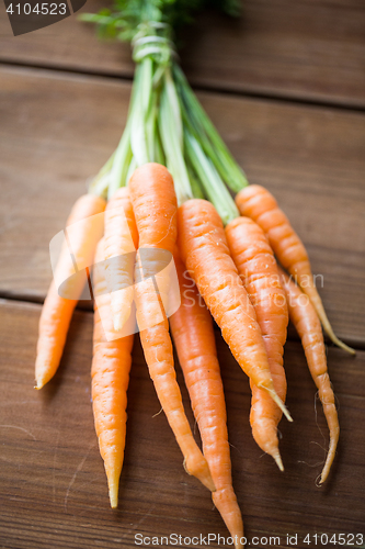 Image of close up of carrot bunch on wooden table