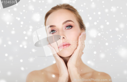 Image of beautiful young woman face and hands over snow