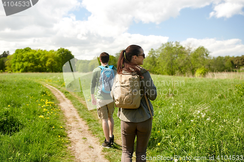 Image of happy couple with backpacks hiking outdoors