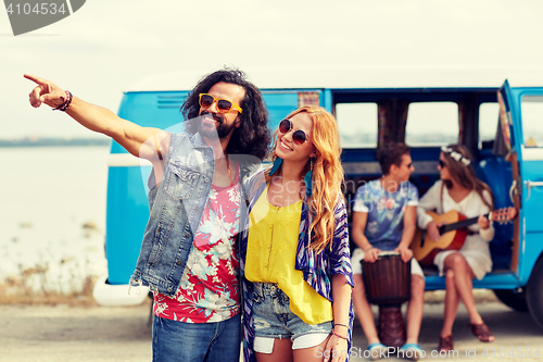 Image of smiling young hippie couple over minivan car