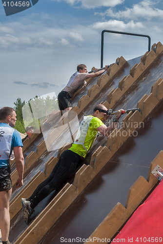 Image of Athlete gets on inclined wall by means of bar