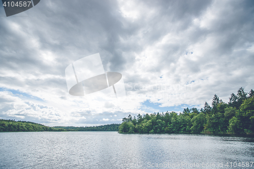 Image of Dark clouds over a forest lake
