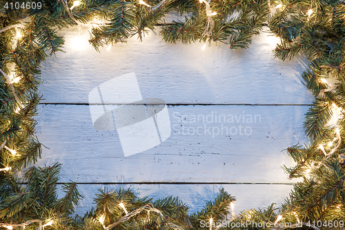 Image of New year light blue wooden background with lightbulb and branches