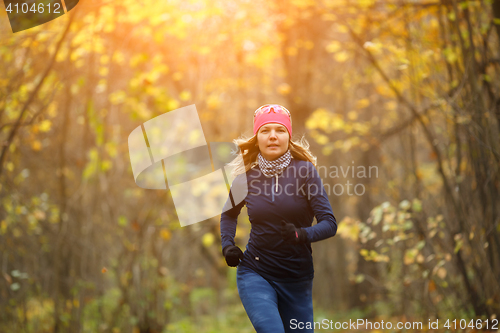 Image of Girl running among autumn leaves