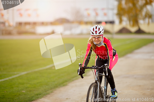 Image of Sportive young woman cycling in park training