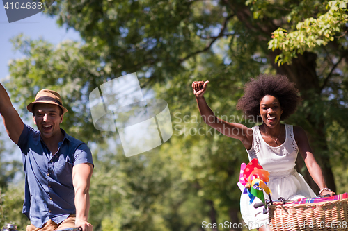 Image of Young multiethnic couple having a bike ride in nature