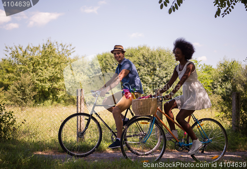 Image of Young multiethnic couple having a bike ride in nature