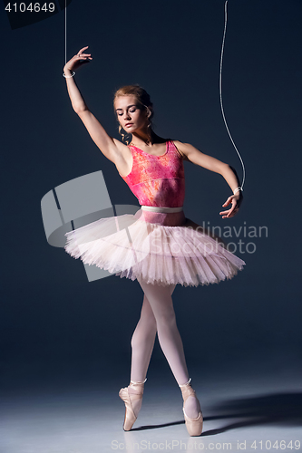 Image of ballet dancer as puppet dancing over gray background
