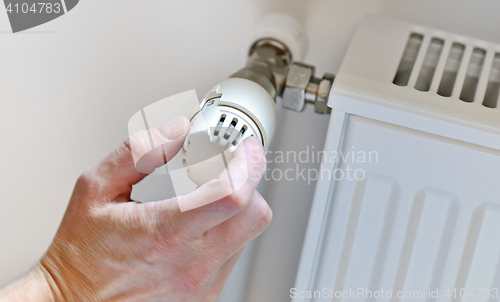 Image of  Hand Adjusting Heater Thermostat